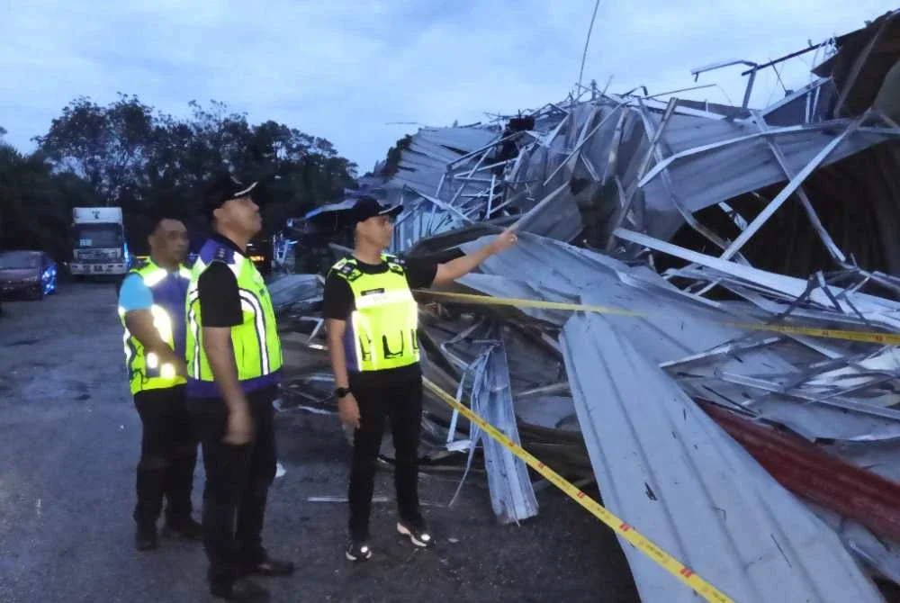 Hadzrat Hussien (depan) meninjau keadaan rumah penduduk yang rosak akibat ribut di Kampung Melayu Raya Pekan Nanas Pontian.