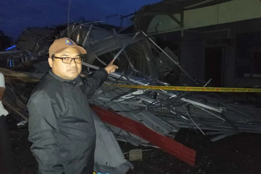 Faizul menunjukkan bumbung rumah yang diterbangkan ribut.