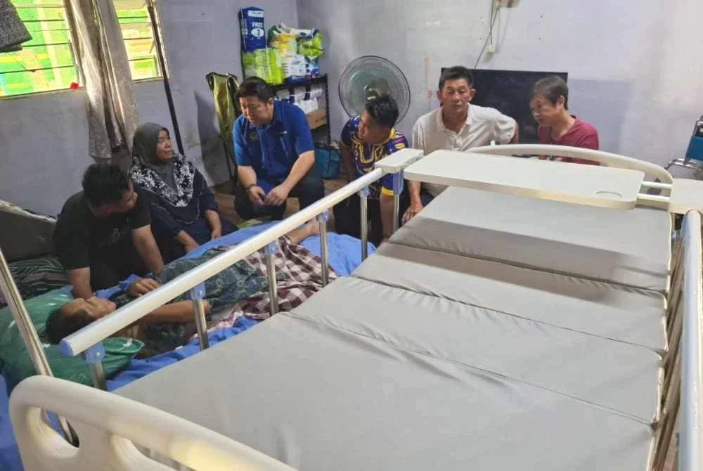 Rosida (dua dari kiri) sewaktu menerima kunjungan Shin Heng (tiga dari kiri) yang menyampaikan sumbangan katil perubatan baharu di kediamannya di Kampung Lubuk Mas, Chenderiang pada Ahad.
