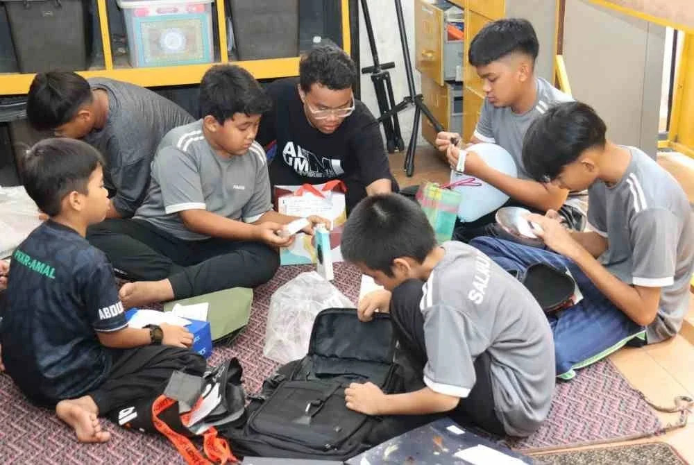 Kanak-kanak dari Pusat Jagaan Kanak-Kanak Yatim/Miskin Rukaiyah ceria membuka hadiah yang disumbangkan oleh Team IOI dan orang awam. Foto: IOIPG