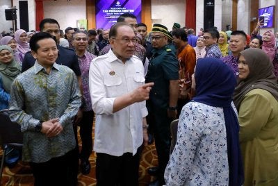 Anwar beramah mesra bersama penjawat awam semasa hadir pada Perhimpunan Bulanan Kementerian Sumber Asli dan Kelestarian Alam pada Isnin. Foto Bernama