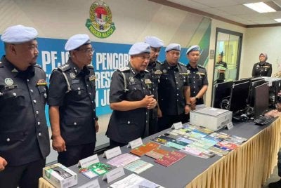 Mohd Rusdi (tiga dari kiri) menunjukkan barangan yang dirampas dalam serbuan sindiket judi dalam talian di Puteri Harbour, Iskandar Puteri.