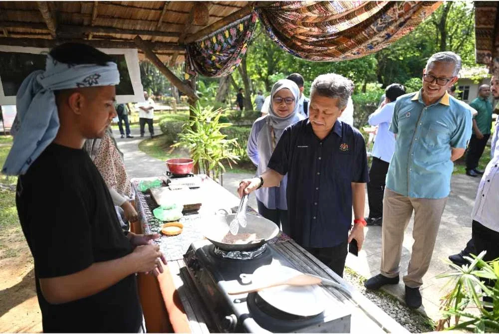 Shaharuddin (tengah) ketika meninjau aktiviti yang dijalankan sempena Majlis Penyerahan Projek Membina dan Menaik Taraf Kampung Budaya Terengganu pada Selasa.