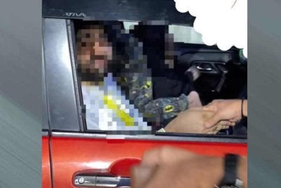 Sebuah keluarga dipercayai warga asing meraih simpati pengguna jalan raya untuk meminta duit. Foto: ihsan pembaca