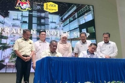 Fadhlina (berdiri, tengah) menyaksikan sesi menandatangani dokumen penyerahan projek siap sempena Majlis Penyerahan Kompleks Pendidikan Negeri Perak di Bandar Meru Raya di sini pada Selasa.