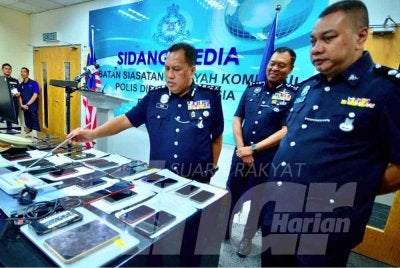 Rusdi (kiri) menunjukkan pelbagai peralatan sindiket macau scam yang ditumpaskan JSJK 23 April lalu. Foto: SINAR HARIAN/ASRIL ASWANDI SHUKOR