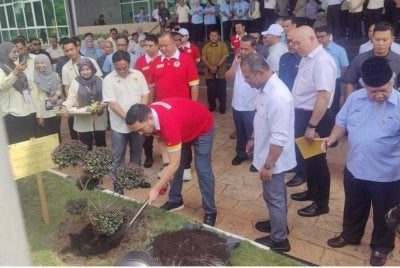 Tengku Amir (tengah) menanam bunga sambil diiringi Amirudin (depan kanan) pada Majlis Perasmian Kompleks Ibu Pejabat JKR sempena Program Gagasan Rumpun Selangor 2026 pada Selasa.