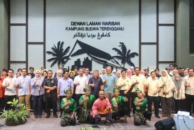 Shaharuddin (tengah) merakam gambar ketika menghadiri Majlis Penyerahan Projek Membina dan Menaik Taraf Kampung Budaya Terengganu, pada Selasa.