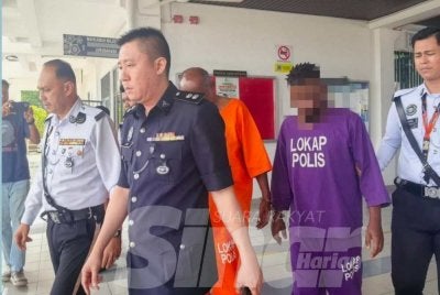 Suspek (kanan) dibawa ke Mahkamah Sesyen Alor Gajah bagi permohonan reman pada Selasa.
