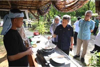 Shaharuddin (tengah) ketika meninjau aktiviti yang dijalankan sempena Majlis Penyerahan Projek Membina dan Menaik Taraf Kampung Budaya Terengganu pada Selasa.