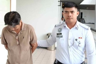 Tertuduh ketika dibawa keluar dari Mahkamah Majistret Ayer Keroh pada Selasa.