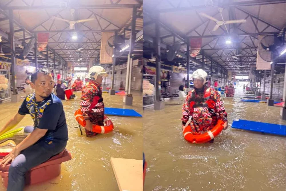 Anggota bomba membantu menyelamatkan mangsa banjir di sebuah medan selera di Petaling Jaya pada Rabu