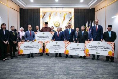 Saarani (tengah) menyempurnakan gimik penyerahan sumbangan 464 lembu korban sempena sambutan Aidiladha.