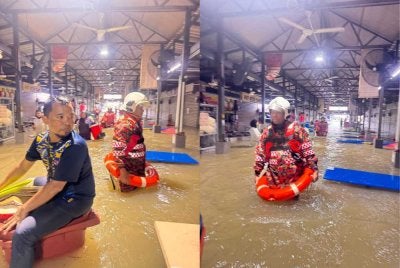 Anggota bomba membantu menyelamatkan mangsa banjir di sebuah medan selera di Petaling Jaya pada Rabu