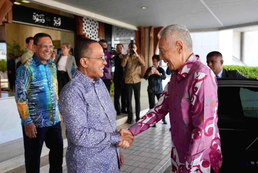 Hsien Loong (kanan) disambut Ahmad Samsuri ketika tiba di Wisma Darul Iman pada Khamis.