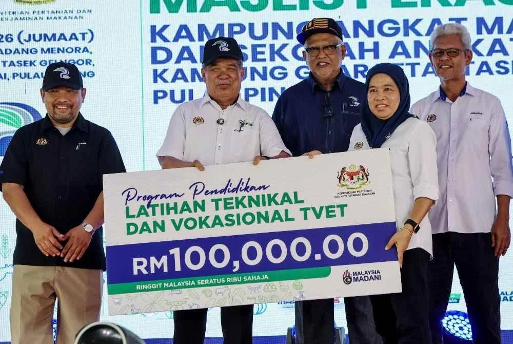 Mohamad Sabu (dua dari kiri) menyampaikan replika cek kepada Pengarah Bahagian Pembangunan Kapasiti dan Latihan Pertanian Hizatul Haliza Hashim. FOTO: Bernama 