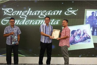 Mohamad Nor (tengah) menyampaikan sijil penghargaan kepada rakan media sempena Malam Mesra Bersama Media AADK Negeri Perak di Royal Perak Golf Club di Ipoh pada Khamis.
