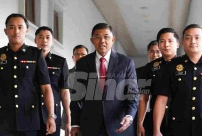 Mohd Nizam (tengah) berdepan empat pertuduhan termasuk menggunakan kedudukan dan pecah amanah wang RM3 juta.