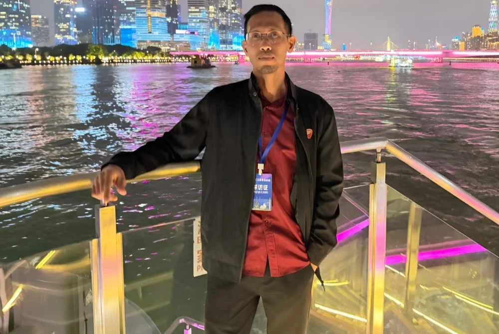 Penulis di atas bot persiaran dengan keindahan cahaya lampu digital sepanjang Sungai Pearl di Guangzhou.