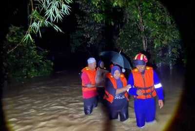 Anggota APMM membantu memindahkan mangsa banjir. Foto APM Kedah