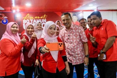 Rozi (dua dari kanan) merakam gambar bersama ahli yang hadir pada majlis Amanat Pengerusi Perhubungan UMNO Negeri sempena sambutan ulang tahun UMNO ke-80 peringkat negeri di Kuala Terengganu, pada Sabtu. 