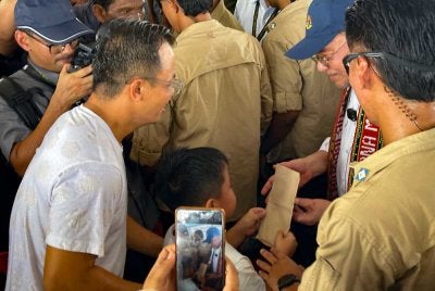 Seorang kanak-kanak, Syam Aariz Rayyan Abdullah,8, menyerahkan sepucuk surat kepada Perdana Menteri Datuk Seri Anwar Ibrahim pada program Perdana Menteri bertemu penduduk di Pekan Baru Pulau Banggi hari ini. Foto Bernama