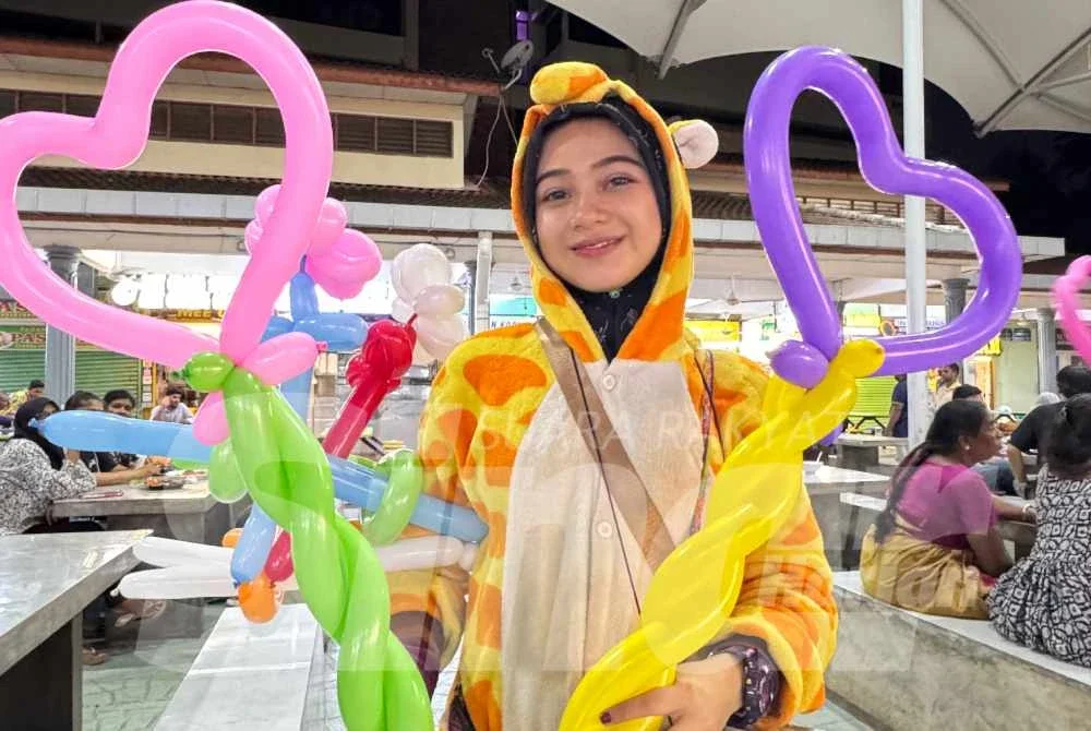 Nurarisya menunjukkan belon yang dibentuk dalam pelbagai bentuk sebelum diberikan kepada kanak-kanak di sekitar Padang Kota.
