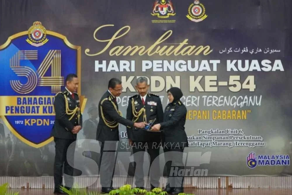 Azman (dua dari kiri) ketika menyampaikan anugerah kecemerlangan KPDN negeri sempena Sambutan Hari Penguat Kuasa ke-54 peringkat KPDN Negeri Terengganu pada Ahad.