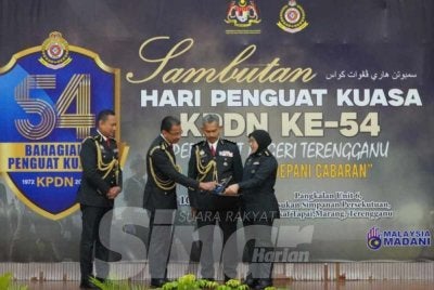 Azman (dua dari kiri) ketika menyampaikan anugerah kecemerlangan KPDN negeri sempena Sambutan Hari Penguat Kuasa ke-54 peringkat KPDN Negeri Terengganu pada Ahad.