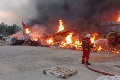 Anggota bomba sedang memadamkan kebakaran di lokasi kejadian pada Ahad.