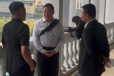 Edmund (tengah) ketika tiba di di Mahkamah Sesyen Kuala Lumpur pada Isnin. 