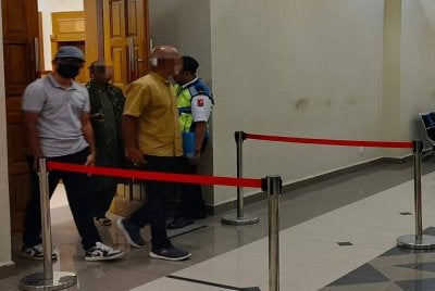 Tertuduh (kiri) hadir untuk pengurusan kesnya di Mahkamah Sesyen di sini pada Isnin.