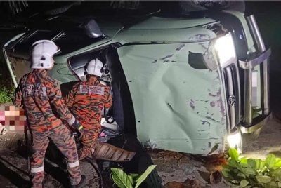 Pasukan bomba melakukan operasi mengeluarkan mangsa kemalangan di Jalan Bukit Belacon Segama, Lahad Datu pada Isnin. - FOTO: Bomba