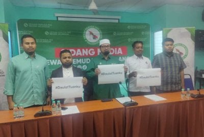 Mohamed Sukri (tengah) bersama kepimpinan Pemuda Pas Selangor menunjukkan pelekat bertulis '#DaulatTuanku' selepas sidang media di Pejabatnya di sini pada Isnin.