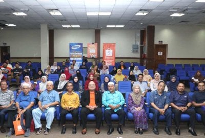Ariffin (lima dari kanan) dan Adli (lima dari kiri) merakam gambar bersama peserta siri jelajah 'Shopee Rai Lokal Jelajah Komuniti' di Dewan Konvensyen YPU, Kuala Terengganu pada Isnin.