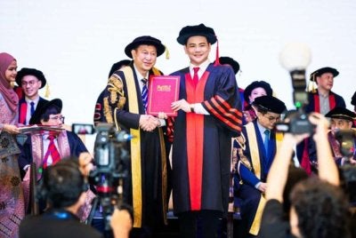 Calvin Khiu (kanan) secara rasmi menamatkan pengajian peringkat Ijazah Kedoktoran DBA.