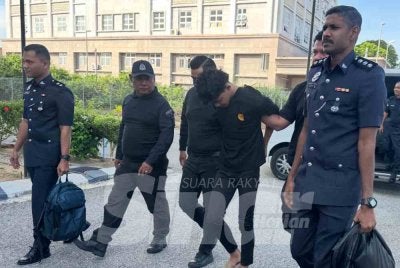 Suspek (tiga dari kanan) tiba di pekarangan Mahkamah Kota Bharu pada Selasa. 