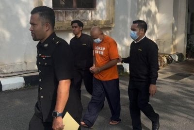 Suspek diiringi pegawai SPRM ketika dibawa ke mahkamah di sini untuk perintah reman pada Selasa. - Foto: SPRM Pahang