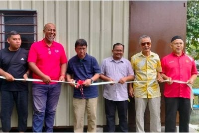 Asmuni (empat dari kanan) memotong riben sebagai simbolik Majlis Penyerahan Kabin Persatuan Penduduk Taman Meru Perdana 2 di sini pada Selasa.