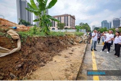 Hannah Yeoh ketika meninjau keadaan runtuhan tembok di Taman Tun Dr Ismail. Foto Bernama 