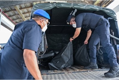 Salah seorang dari empat mayat yang ditemukan di perairan Pangkor dibawa ke Hospital Seri Manjung untuk dibedah siasat di Jeti PPM Kampung Acheh hari ini. - Bernama
