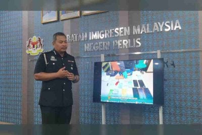 Mohammad A’sim menunjukkan gambar warga China yang ditahan pada bulan lalu pada sidang akhbar pada Selasa.