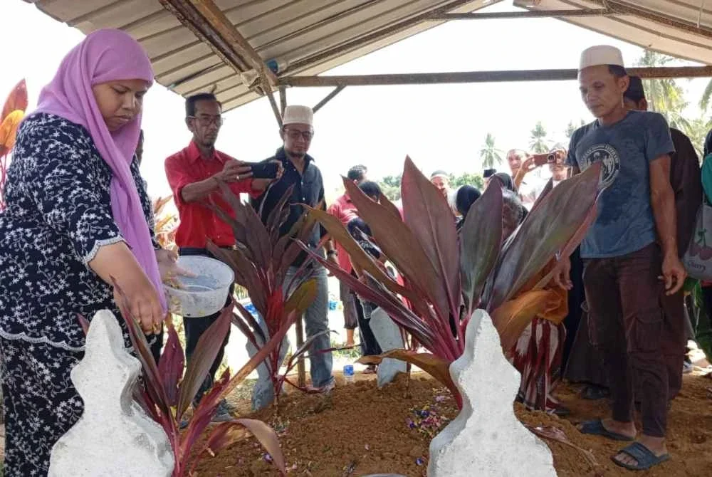 Ibu mangsa, Suria Sulong dan bapa, Nur Shahila, Azman Wahab ketika urusan pengebumian di Tanah Perkuburan Islam Jeram Manir,Kuala Terengganu pada Rabu.