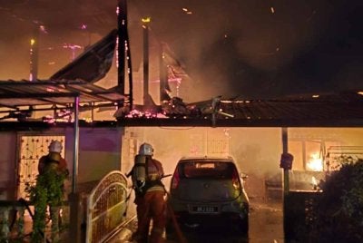 Anggota bomba yang tiba mendapati api sedang marak dengan anggaran kemusnahan sekitar 70 peratus. Foto JBPM Perak