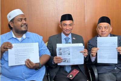 Dari kiri, Muhammad Hafis, Mohd Yusni dan Muhammad Fauzi menunjukkan dokumen yang akan diserahkan kepada SPRM Pulau Pinang selepas sidang media di Bangunan DUN Pulau Pinang pada Rabu.