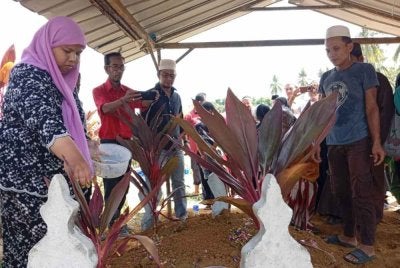 Ibu mangsa, Suria Sulong dan bapa, Nur Shahila, Azman Wahab ketika urusan pengebumian di Tanah Perkuburan Islam Jeram Manir,Kuala Terengganu pada Rabu.