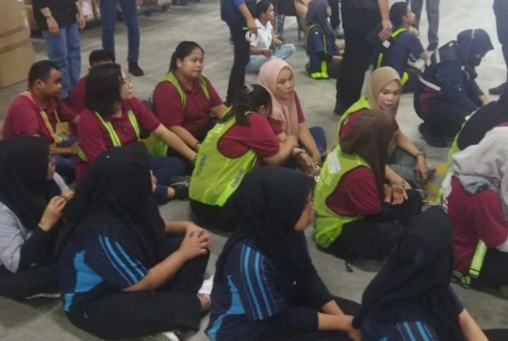Antara individu yang diperiksa JPN dalam serbuan di dua gudang pakaian di Shah Alam pada Khamis.