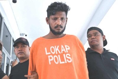Manimaran (tengah) didakwa di Mahkamah Majistret Manjung atas pertuduhan membunuh seorang lelaki warga emas ketika menyamun rumah mangsa minggu lepas.