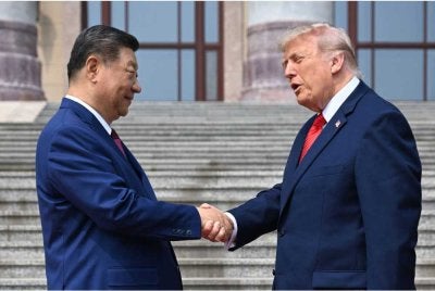 Trump (kanan), berjabat tangan dengan Xi di Dewan Besar Rakyat di Beijing. Foto Bernama