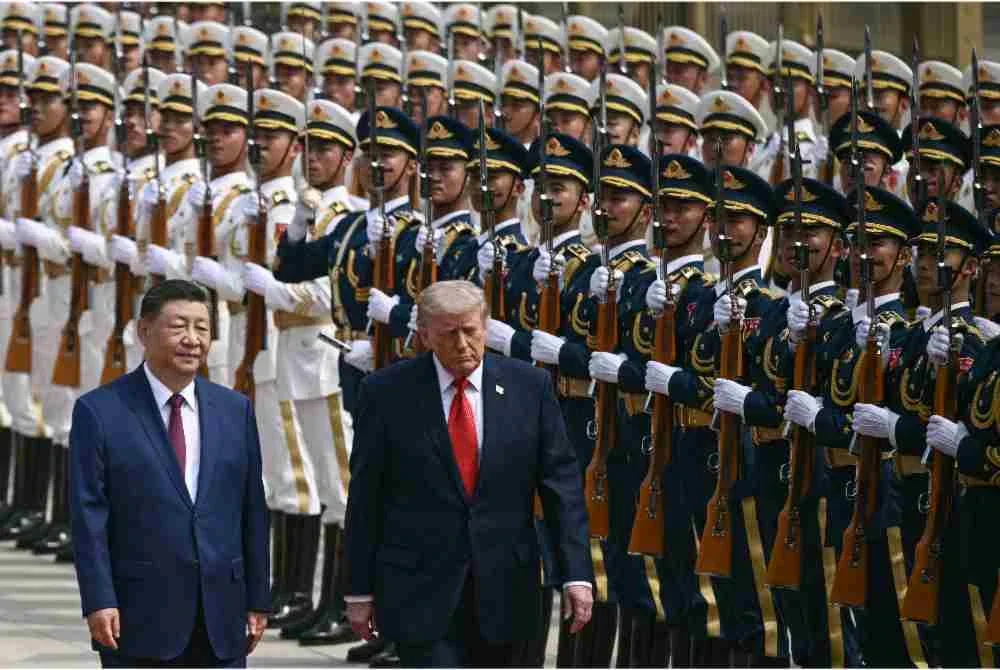 Trump (kanan) dan Xi Jinping (kiri) memeriksa kawalan kehormatan semasa upacara sambutan di Beijing. Foto: AFP
